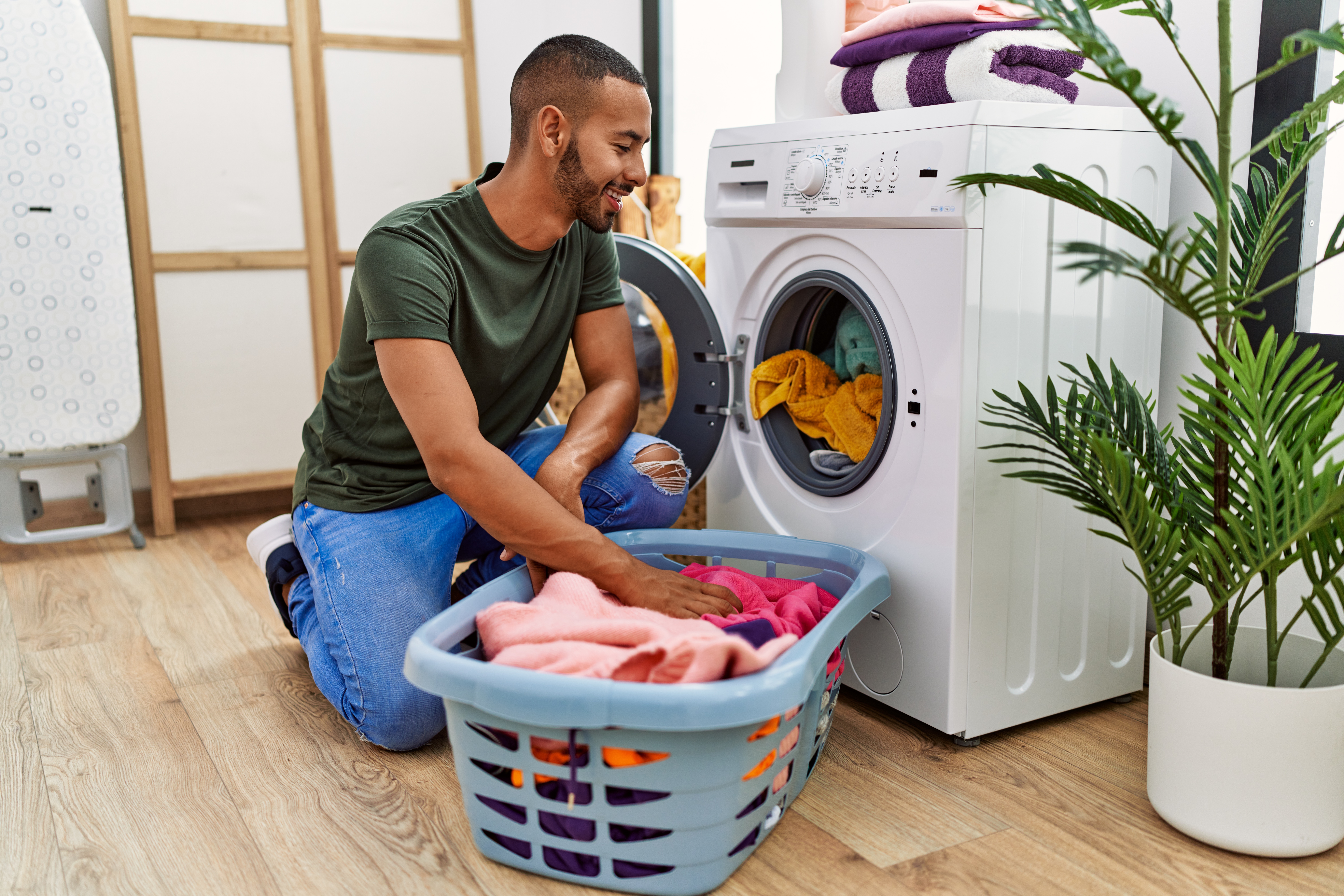 Man doing laundry at home using washing machine