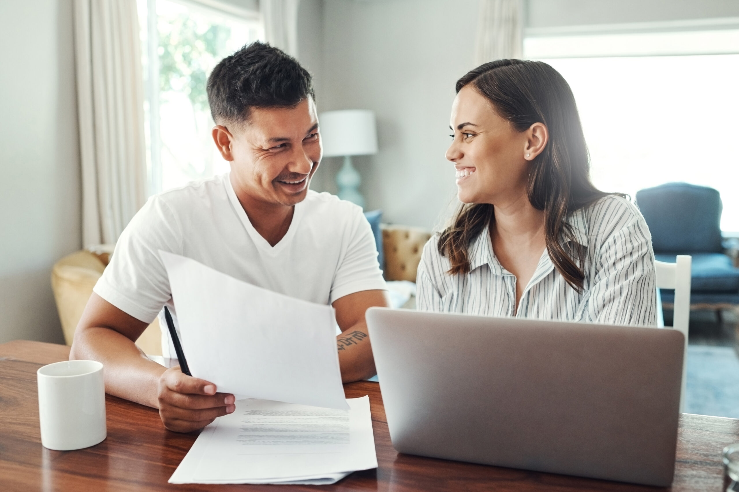 Couple paying bills online using a laptop